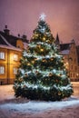 Christmas tree with new year holiday decoration in a city street at night, houses with lights, winter, snow Royalty Free Stock Photo