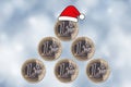 Christmas tree. One Euro coins are stacked in the form of a pyramid and a Santa Claus hat on a blurred New Year\'s background Royalty Free Stock Photo