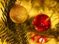 Glittering golden bauble and blurred red bauble in Christmas tree Royalty Free Stock Photo