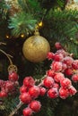 Christmas tree with red balls and holly berries as decor and lights with copy space on blurred bokeh background in mall. Close up. Royalty Free Stock Photo