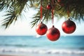 Christmas tree red ornaments hanging on palm tree on tropical beach. Red Christmas baubles on a palm tree against sea or ocean Royalty Free Stock Photo