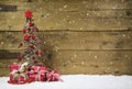 Christmas tree with red presents and snow on wooden snowy background. Royalty Free Stock Photo