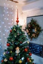 Christmas tree with a red top decorated with colorful toys and balls stands in the room Royalty Free Stock Photo