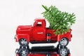 Christmas tree in a red Christmas truck on a white background, reflected in a mirror surface. Concept - greeting card for Royalty Free Stock Photo