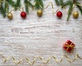 Christmas tree, balls, gift, serpentine on an old light wooden background. New Year holiday Royalty Free Stock Photo