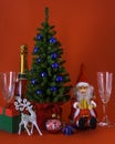 Christmas tree with reindeer  santa claus  gift box  champagne  glasses  bell and ornament on red background Royalty Free Stock Photo