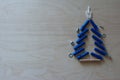 Christmas tree shape with dowels, nuts, screws on a plywood background. Cope space, top view