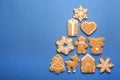 Christmas tree shape made of delicious gingerbread cookies on blue background, flat lay. Space for text Royalty Free Stock Photo