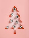 Christmas tree shape made with silver disco balls on pastel pink background. Minimal Xmas eve or Happy New Year celebration Royalty Free Stock Photo