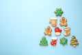 Christmas tree shape made of tasty homemade cookies on light blue background. Space for text Royalty Free Stock Photo