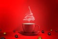 Christmas tree shape of steaming coffee cup and christmas ball on floor on a red background. Copy Space