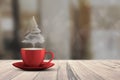 Christmas tree shape of steaming coffee cup on white wooden floor against bokeh background. Copy Space