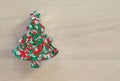 A Christmas tree shaped cookie cutter filled with candy sprinkles on a wood background Royalty Free Stock Photo
