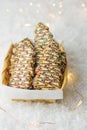 Christmas tree shaped shortbread cookies decorated with chocolate icing multicolored sugar sprinkles in wicker basket golden light