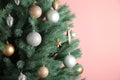 Christmas tree with silver and gold balls on pink background. Space for text Royalty Free Stock Photo