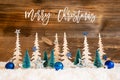 Christmas Tree, Snow, Blue Star, Ball, Text Merry Christmas, Wooden Background Royalty Free Stock Photo