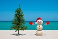 Christmas Tree and Snowman. Sandy snowman on the beach. Merry Christmas. Happy New Year. Smiling snowman. Royalty Free Stock Photo