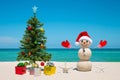 Christmas Tree and Snowman. Sandy snowman on the beach. Merry Christmas. Happy New Year. Smiling snowman Royalty Free Stock Photo