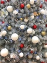 Christmas tree with snowy branches and red and white balls toys, festive background decor for New Year eve is greeting card. Royalty Free Stock Photo