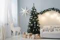 Christmas tree stands in the interior of the living room with a sofa and a deer with lights Royalty Free Stock Photo