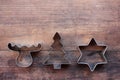 Christmas tree, star, and deer shaped cookie cutters on a wooden table. Christmas background. Royalty Free Stock Photo