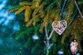 Christmas tree toy, the heart hangs on a branch of a living Christmas tree outside