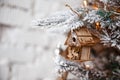 Christmas tree toy house hanging on a Christmas tree on the background of a white brick wall Royalty Free Stock Photo