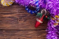Christmas holidays composition with red gliter cone and purple tinsel on brown wood background