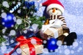 Christmas tree, toy snowman in santa hat with gift boxes on a shiny blue background. Close-up Royalty Free Stock Photo