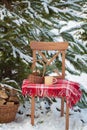 Christmas-tree toys in basket with cup of coffee on wool blanket on the chair near firewood