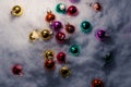 Christmas tree toys, colorful glass balls scattered on white snow, top view. Royalty Free Stock Photo