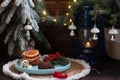 A Christmas tree with toys and a plate with red viburnum berries and orange slices.