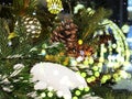 Christmas tree with  branch with pine cone snow gold confetti decoration at blurred light night in Tallinn old town winter Royalty Free Stock Photo