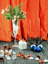 Christmas tree in white decorative goblet, white gift box, blue balls, candlestick with red candles and decorative stones