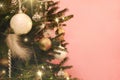 Christmas tree with white and golden decorations on pink background