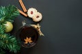 Christmas tree and wineglass of mulled wine with cookies and orange on the black table top view Royalty Free Stock Photo