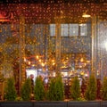 Christmas trees are decorated with garlands at the restaurant window on new year eve