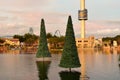 Christmas trees reflected in the lake and sky tower on sunset background in International Drive area. Royalty Free Stock Photo