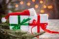 Christmas white boxes or presentes with santa hat on white wooden table Royalty Free Stock Photo