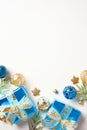 Christmas vertical banner design. Flat lay blue and gold gift boxes, baubles, fir branches on white background. Top view with copy Royalty Free Stock Photo