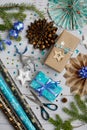 Christmas vertical composition. Blue gift boxes, stars, sparkles, scissors, wrapping paper on a light wooden background. Top view Royalty Free Stock Photo