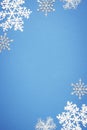 Christmas vertical composition with border of white decorative snowflakes on blue background. Flat lay, top view, copy Royalty Free Stock Photo