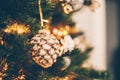 Christmas vintage toy pine cone on Christmas tree. Holiday background with bokeh lights Royalty Free Stock Photo