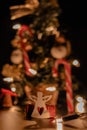 Christmas white angel brings gifts under the tree, which is decorated with golden lights. Tiny gifts wrapped in red paper and a Royalty Free Stock Photo