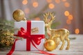 Christmas white box or present with golden balls and deer for secret santa on wooden table Royalty Free Stock Photo