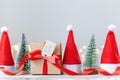 Christmas white box or present with red ribbon from Secret Danta with santa hat and xmas trees. Happy holiday concept Royalty Free Stock Photo