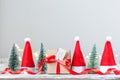 Christmas white box or present with red ribbon from Secret Danta with santa hat and xmas trees. Happy holiday concept Royalty Free Stock Photo