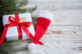 Christmas white box or present with red ribbon for secret santa with santa hat on wooden table Royalty Free Stock Photo