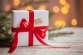 Christmas white box or present with red ribbon for secret santa on wooden table Royalty Free Stock Photo