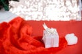 Christmas white gift box with a large bow standing on red hat santa calus against a background bokeh of twinkling golden bokeh